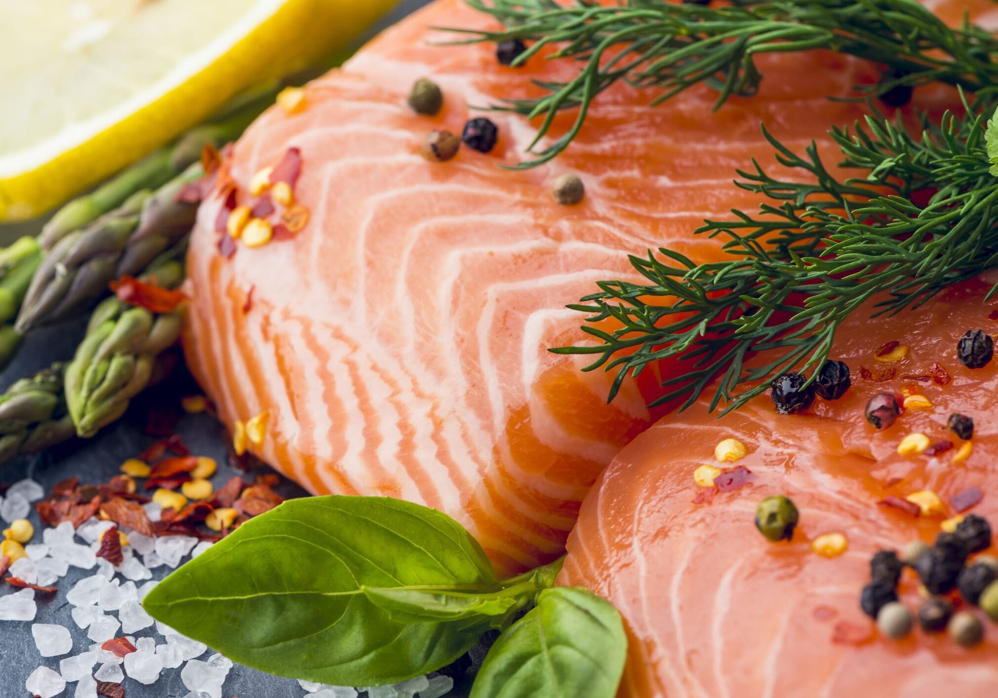 Fresh salmon with herbs and lemon slices.